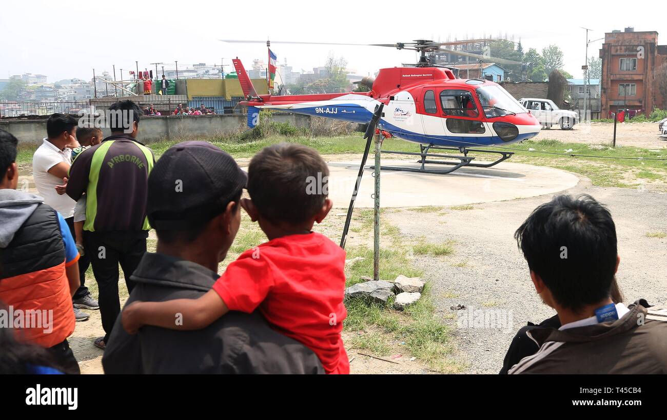 Kathmandu, Nepal. Xiv Apr, 2019. La gente guarda l'elicottero che trasporta i cadaveri delle vittime uccise in aeromobili collisione in Nepal di Lukla aeroporto all ospedale di insegnamento a Kathmandu, Nepal, Aprile 14, 2019. Almeno due persone sono state uccise dopo un aeromobile di vertice aria entra in collisione con un elicottero a Lukla Airport in Nepal la domenica mattina, secondo le autorità locali. Credito: Sunil Sharma/Xinhua/Alamy Live News Foto Stock