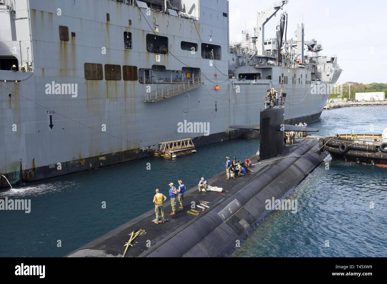 APRA HARBOR, Guam (11 marzo 2019) - USS Oklahoma City (SSN 723), una Los Angeles-class sottomarino, si prepara a moor accanto a USNS Cesar Chavez (T-AKE 14) durante un esercizio di Apra Harbor, Marzo 11. L'esercizio mira a valutare le capacità di USNS navi di sottomarini di servizio mentre in porto e in corso. Foto Stock