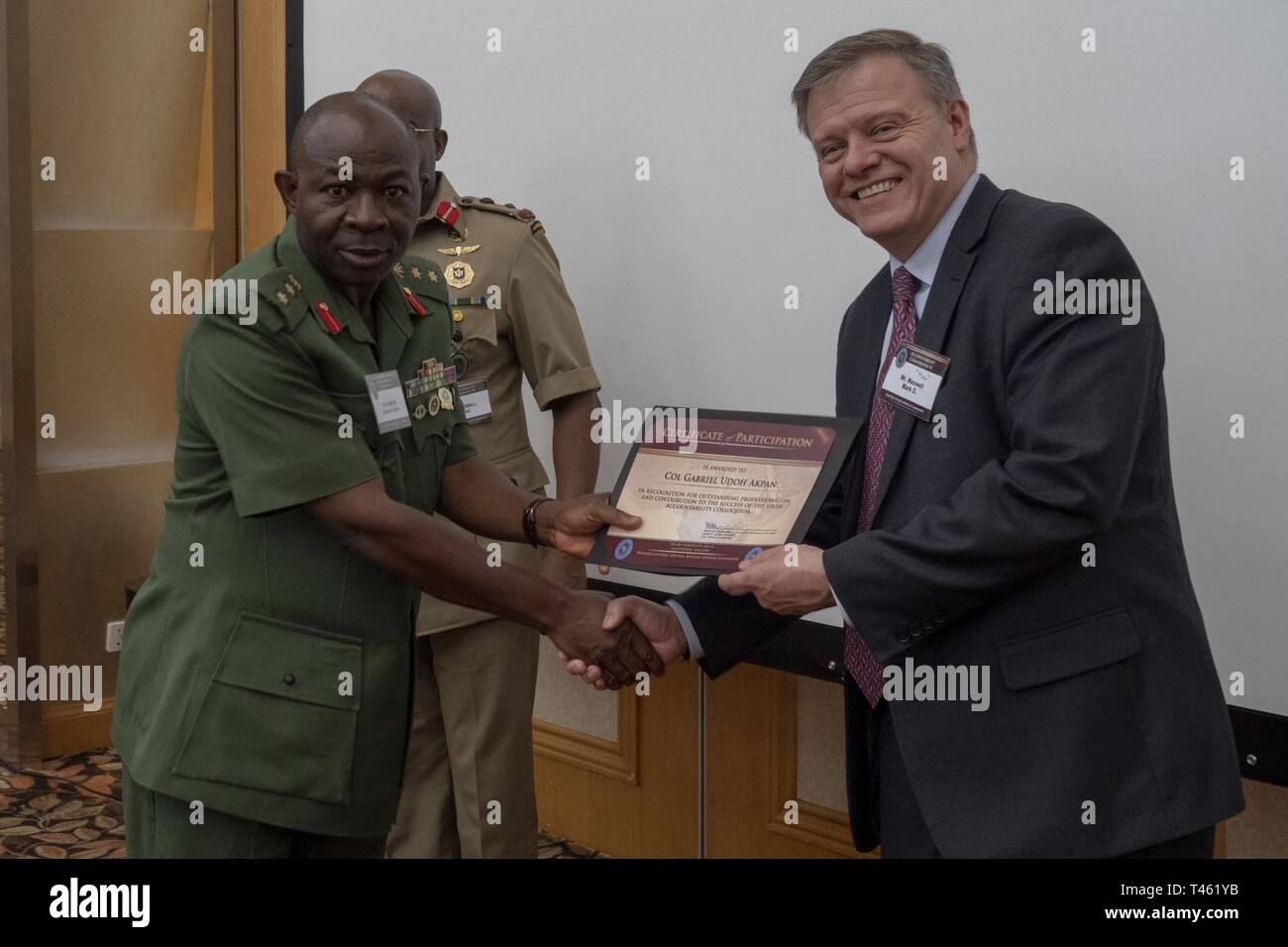 Il colonnello Gabriel Udoh Akpan riceve il suo certificato di partecipazione dal sig. Mark D. "Max" Maxwell sul finale il giorno del colloquio di responsabilità VI a Lilongwe, Malawi, il 28 febbraio 2019. L'Accountability Colloquio è un evento annuale ospitato da Stati Uniti Africa il comando dell'Ufficio di consulenza legale che mira a creare un forum collaborativo per i comandanti militari e i loro consulenti legali per lo scambio di informazioni su argomenti correlati all'africano di operazioni militari. Questa iterazione featured oltre 80 partecipanti provenienti da 30 nazioni Africane. Foto Stock