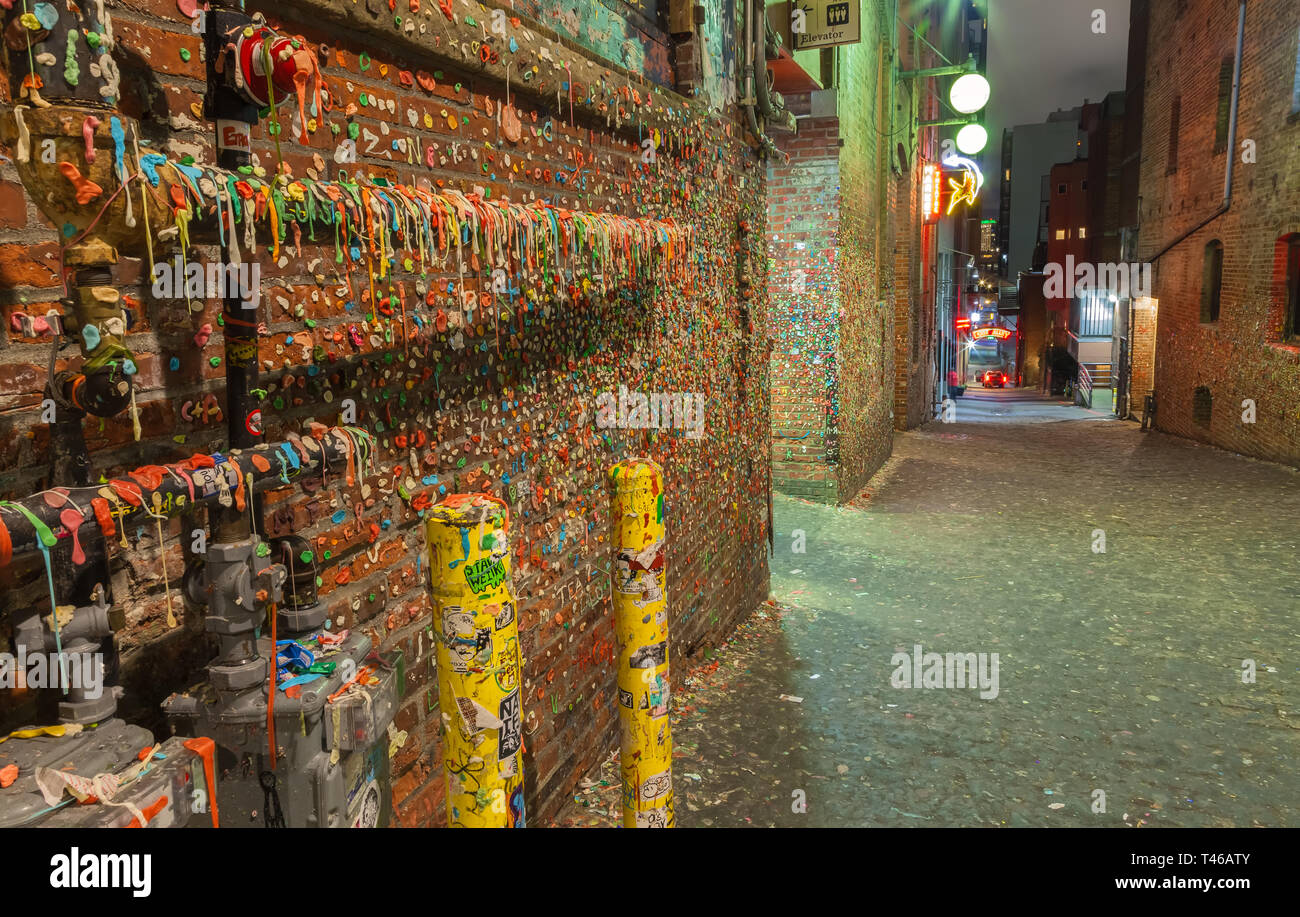 Popolare attrazione turistica, la gomma di parete dietro il Mercato di Pike Place a Seattle, Washington, Stati Uniti, di notte. Foto Stock