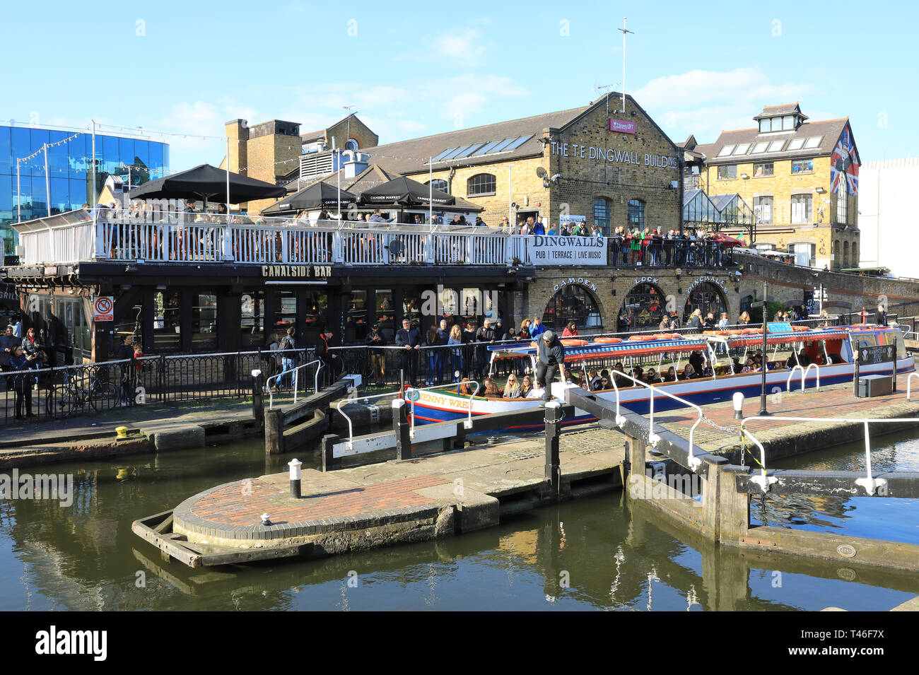 Barge con turisti di passaggio attraverso il Camden Lock sul Regents Canal, nel sole primaverile, a nord di Londra, Regno Unito Foto Stock