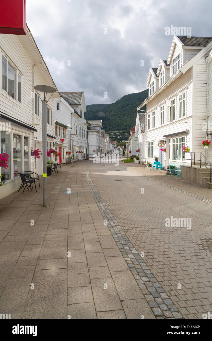 Nordfjordeid, Norvegia - Luglio 2016: la strada principale della città Nordfjordeid con un retro di edifici bianchi. Curva di strada con vecchie belle case bianche in histor Foto Stock