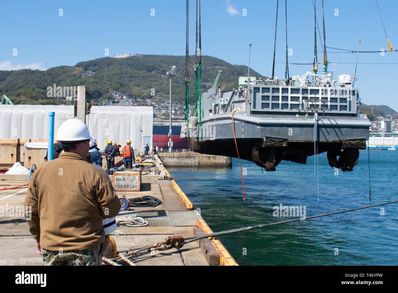 SASEBO, Giappone (Mar. 13, 2019) Landing Craft, Utility (LCU) 1631, assegnato alla spiaggia navale unità (NBU) 7, viene sollevato fuori dall'acqua in preparazione per docking in India Pier. NBU 7 serve come la formazione e la valutazione della fattibilità del comando per LCUs, landing craft, cuscini ad aria (LCACs) e beach party squadre distribuita in Giappone. Foto Stock