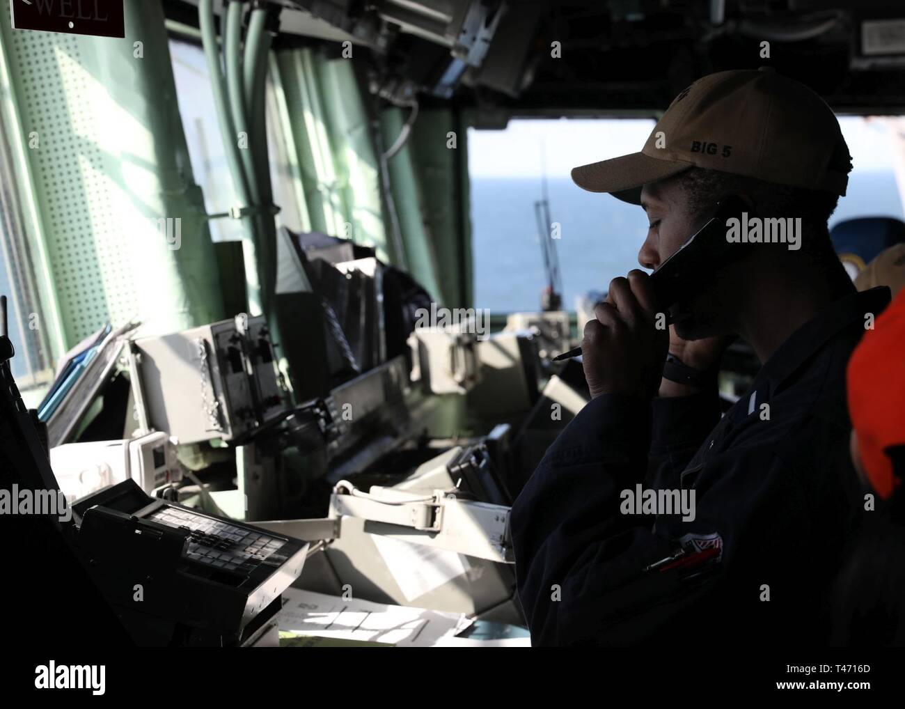 OCEAN (Mar. 14, 2019) Tenente junior grade Tilman Dunbar utilizza il telefono durante una precisione evoluzione di ancoraggio sul ponte a bordo dell'assalto anfibio nave USS Bataan (LHD 5). La nave è in corso conduzione di esperimenti in mare. Foto Stock