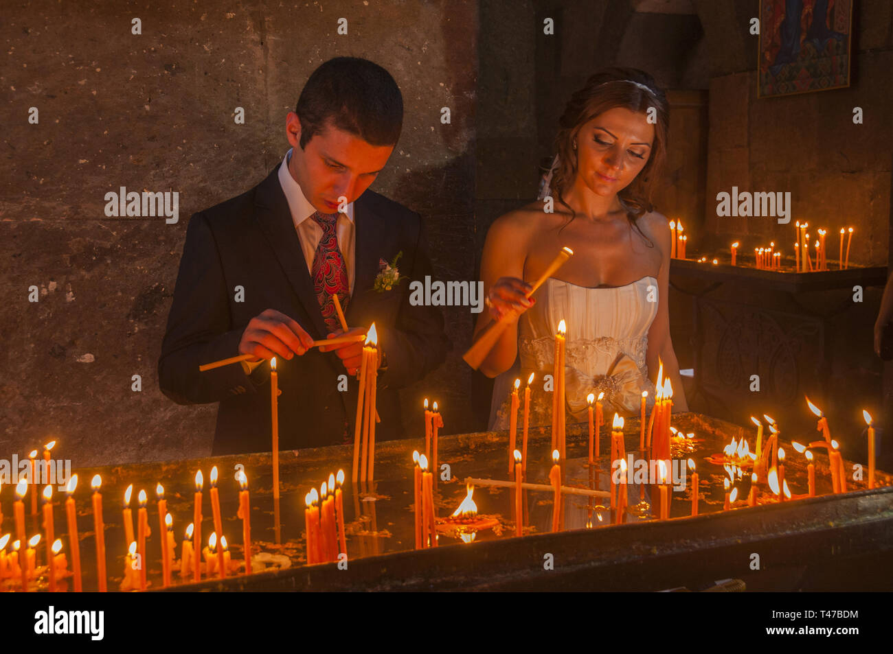 Armenia, Vagharshapat (Etchmiadzin), persone di preghiera di illuminazione candele ad Etchmiadzin Santa Sede cattedrale, 301-303 d.c. costruita da Armenia il santo patrono GRE Foto Stock