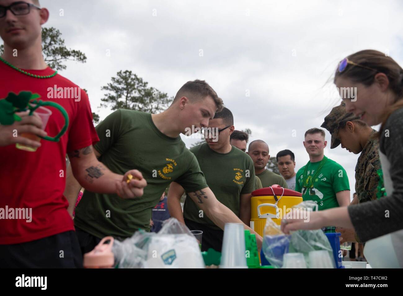 Stati Uniti Marines e membri della famiglia di raggiungere i rinfreschi durante un san Patrizio fun run al Marine Corps Air Station New River, North Carolina, 8 marzo 2019. Marine Logistica Aerea Squadron condotta fun run per favorire la coesione unità, costruire un cameratismo e accrescere il coinvolgimento della famiglia per i Marines dello squadrone. i Marines sono assegnati a Malles-26, Marine Aircraft Group 26, 2° velivolo marino ala. Foto Stock