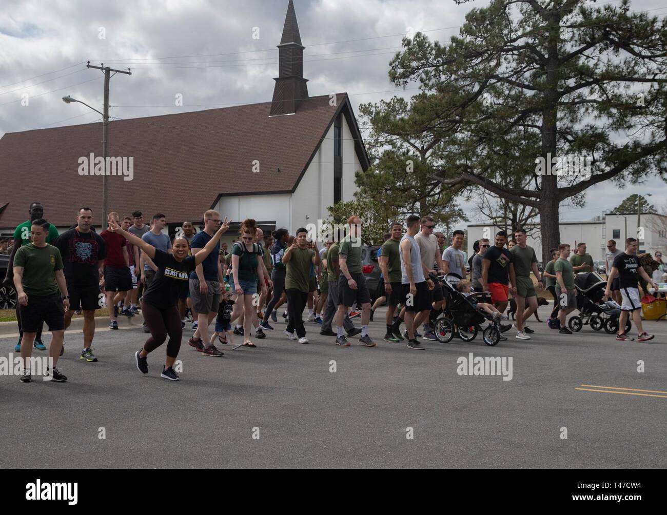 Stati Uniti Marines e membri della famiglia a piedi verso il punto di partenza prima di un san Patrizio fun run al Marine Corps Air Station New River, North Carolina, 8 marzo 2019. Marine Logistica Aerea Squadron condotta fun run per favorire la coesione unità, costruire un cameratismo e accrescere il coinvolgimento della famiglia per i Marines dello squadrone. i Marines sono assegnati a Malles-26, Marine Aircraft Group 26, 2° velivolo marino ala. Foto Stock