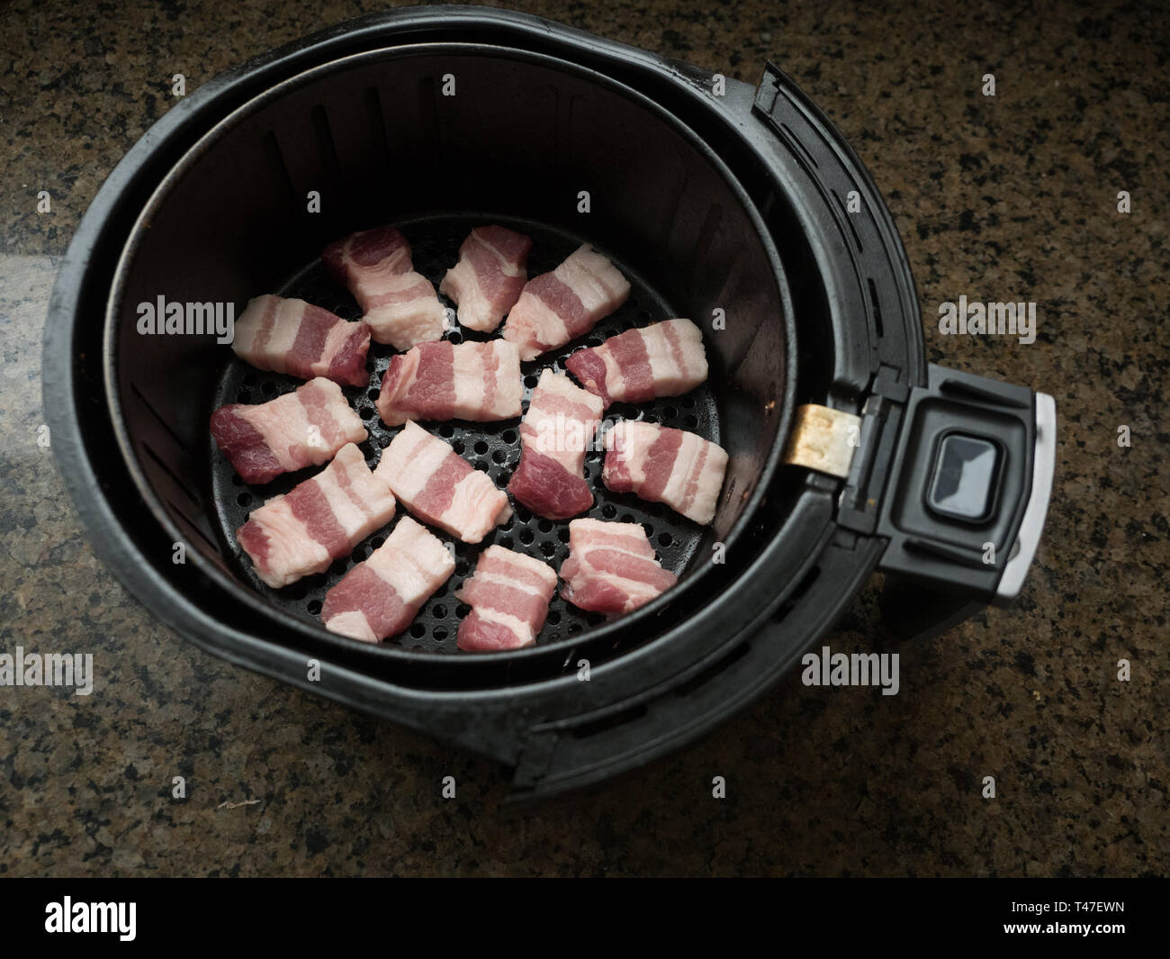 Cuocete il panino di maiale in un cestino della friggitrice ad aria Foto Stock