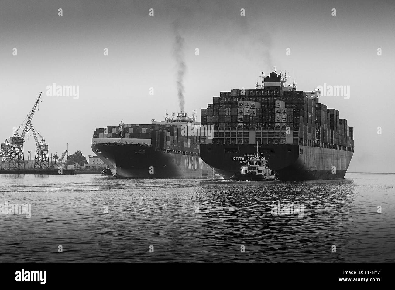 Il contenitore di partenza nave KOTA IL CAHAYA, passando vicino all'arrivo YM unanimità nella trafficata Los Angeles canale principale al Porto di Los Angeles. Foto Stock