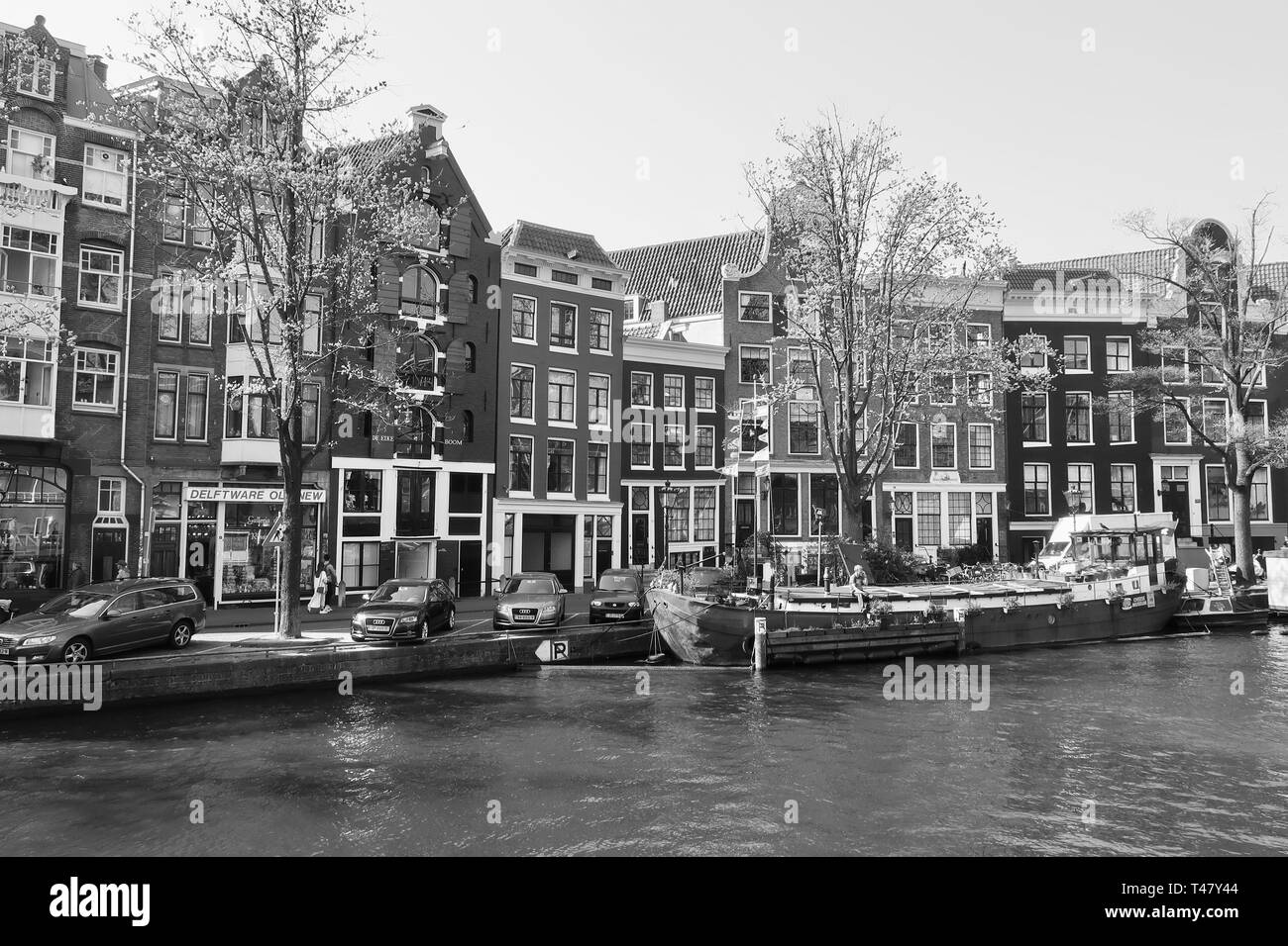 Amsterdam, Paesi Bassi - Aprile 2019: barche, canali, biciclette e alti edifici. Foto Stock