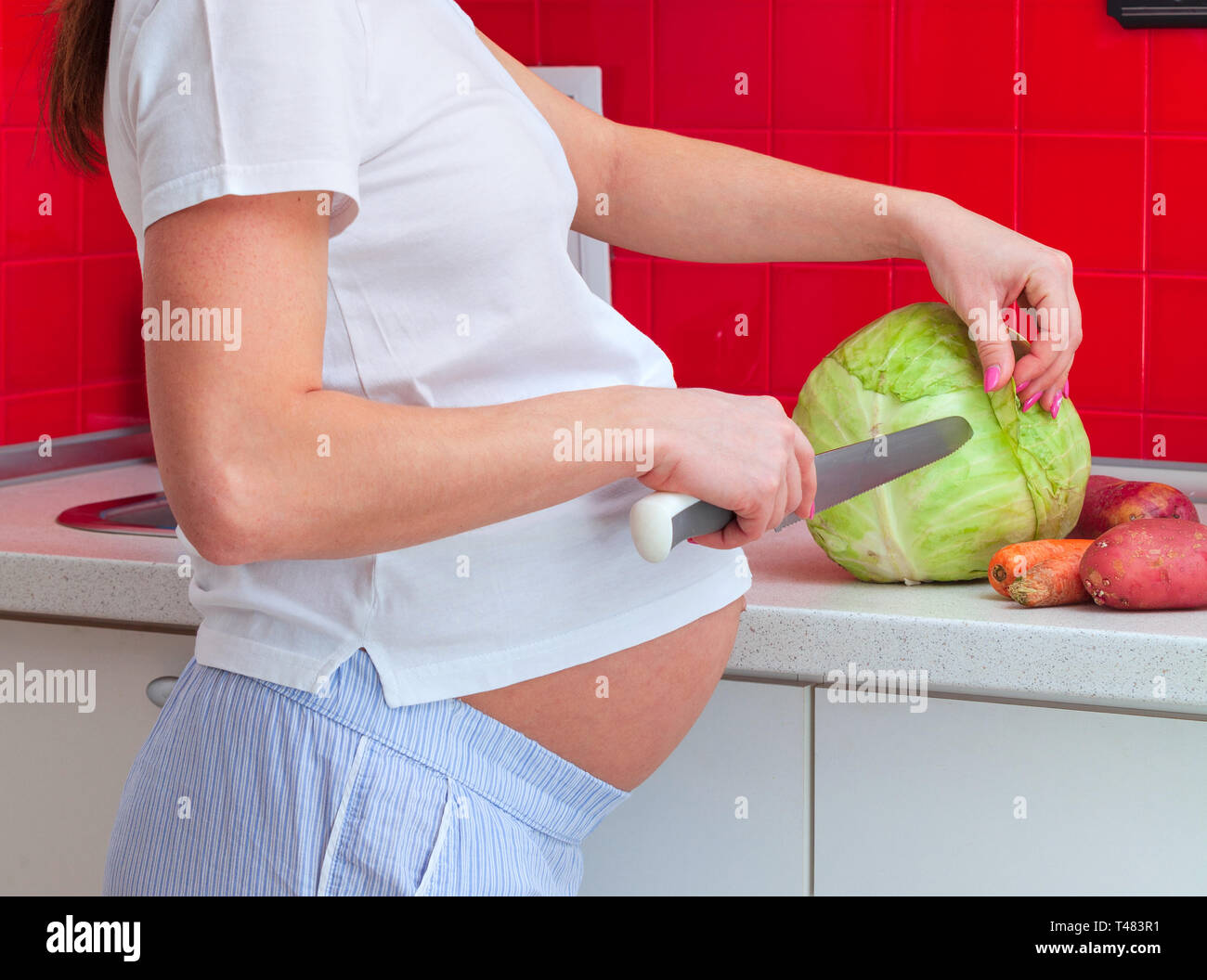 Donna incinta nella preparazione degli alimenti. Foto Stock
