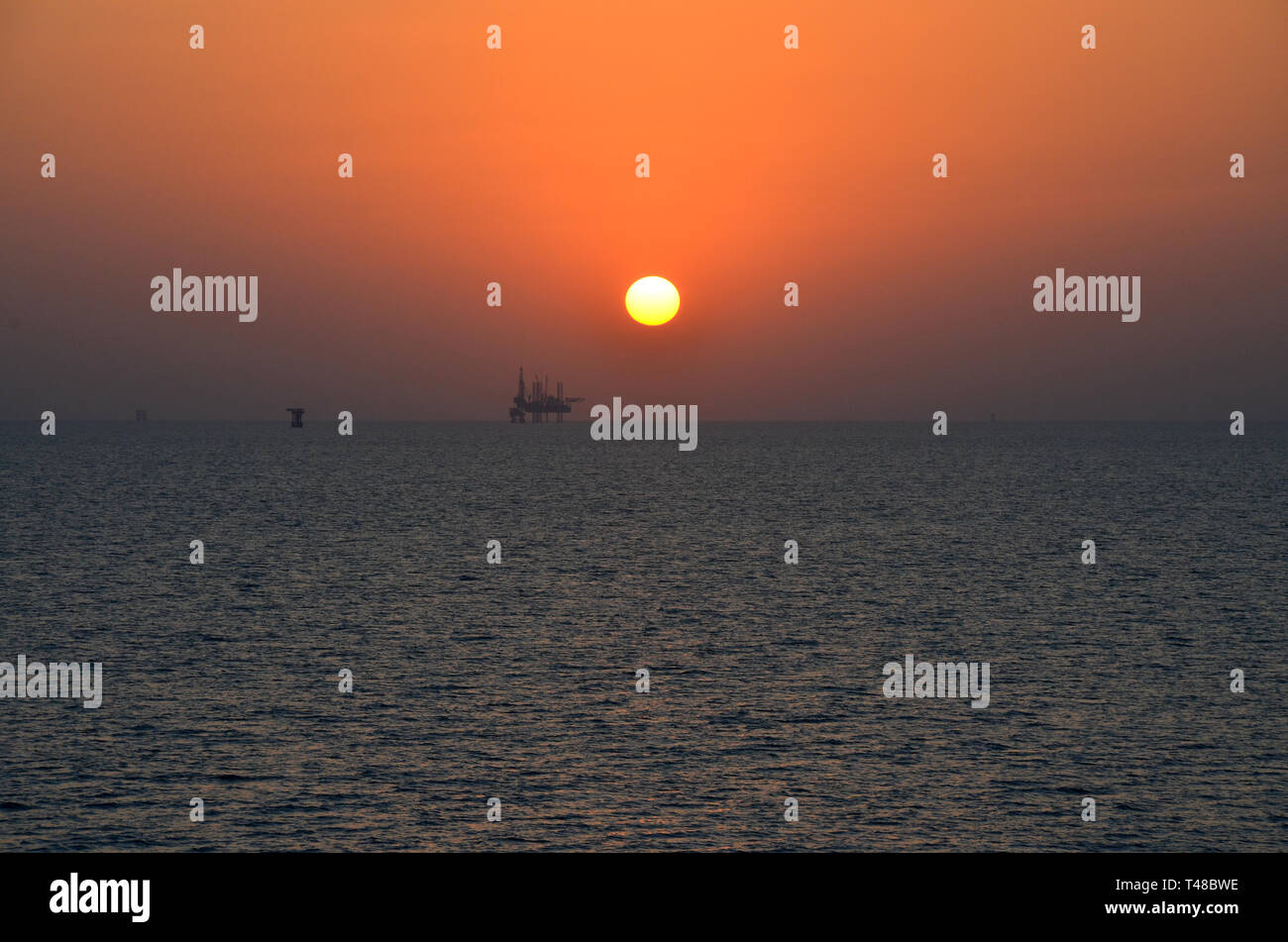 Aprire l'acqua tramonto persion Gulf Oil Platform Foto Stock