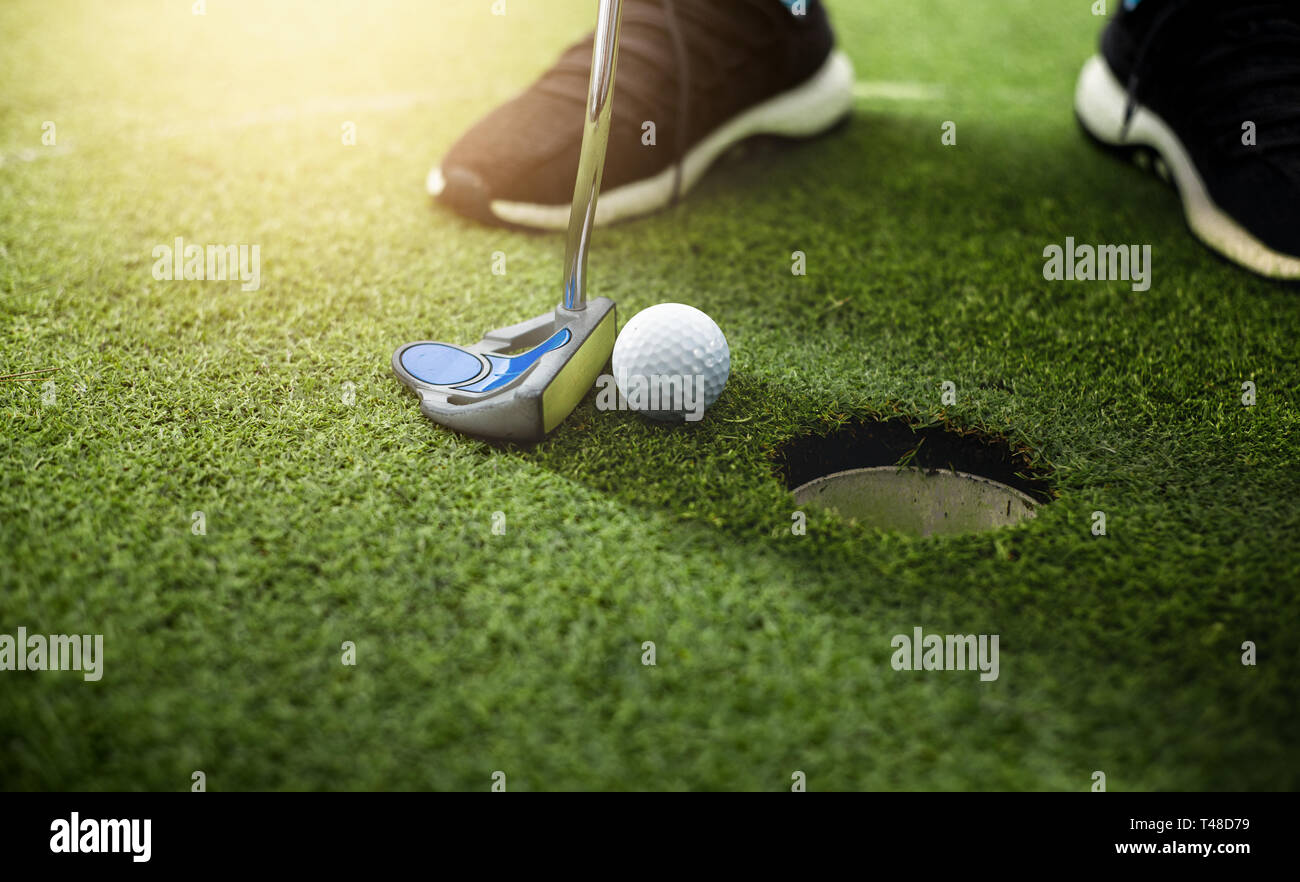 Giocatore di golf putting pallina da golf approccio al foro di golf sul green golf Foto Stock