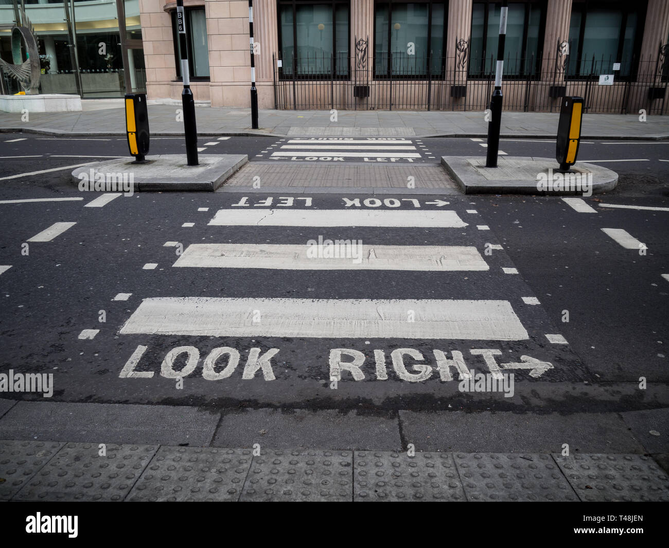 Un crosswalk a Londra avverte i pedoni a guardare a destra per i veicoli che sopraggiungono in senso contrario Foto Stock
