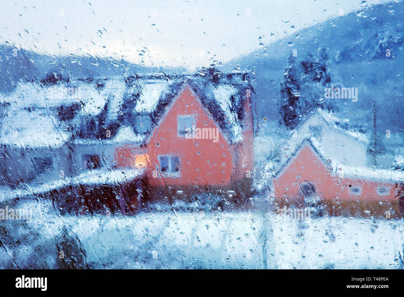 Gocce di pioggia su un vetro di finestra, vista offuscata di una casa in inverno, Witten, Renania settentrionale-Vestfalia, Germania Foto Stock