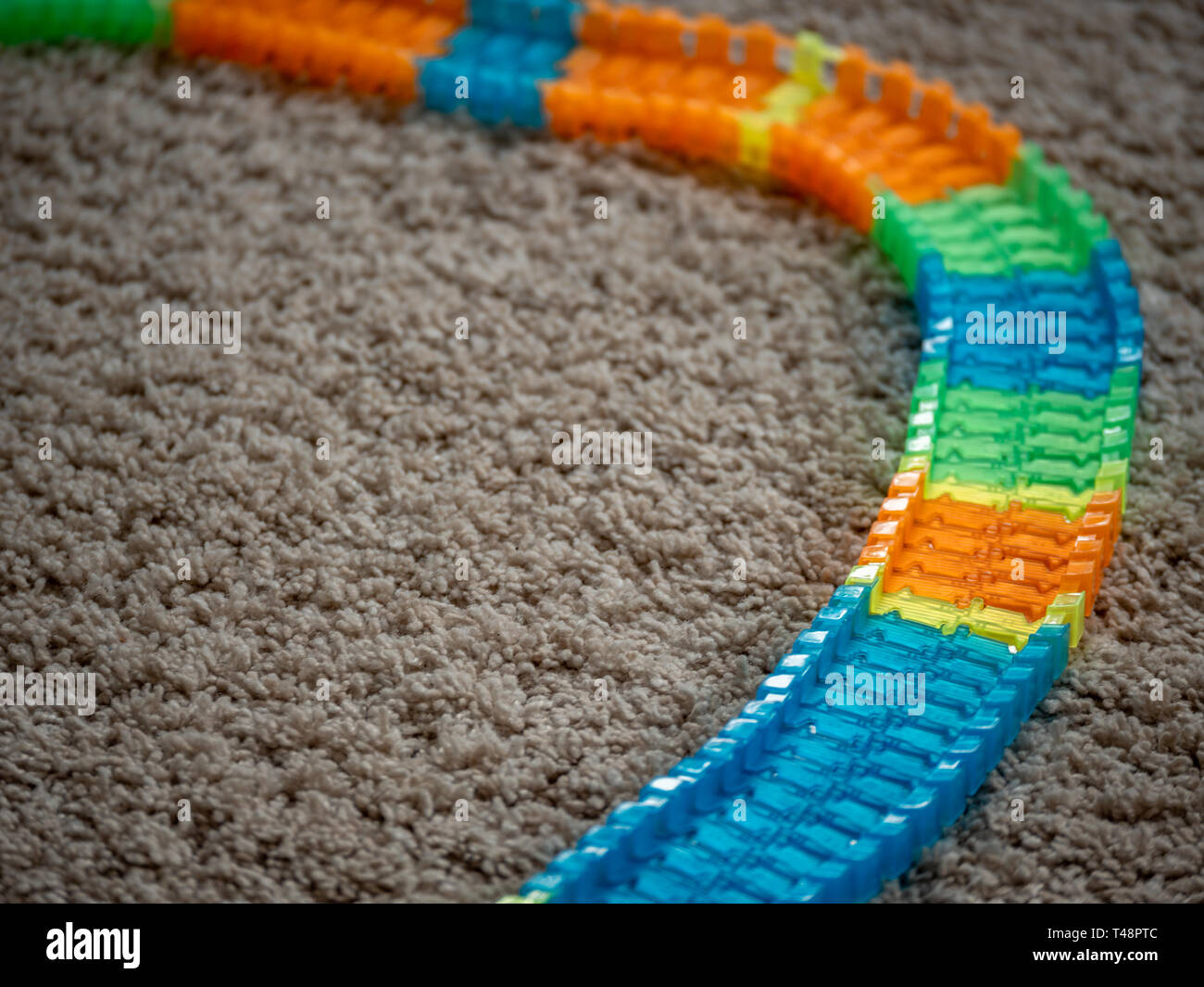 Immagine del giocattolo auto via e colorato elementi traccia su un tappeto Foto Stock