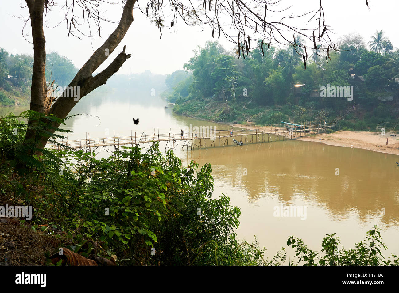 Bambù in legno ponte sul fiume Nam Khan a Luang Prabang, Laos Aprile 2019 Foto Stock