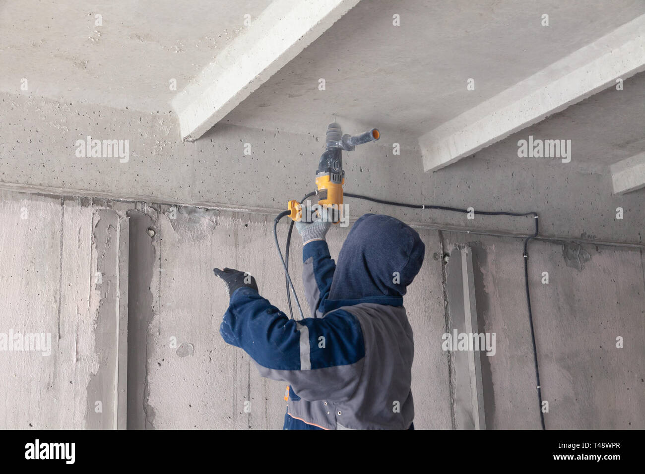 Lavoratore builder consente il cablaggio elettrico, trapani il soffitto con  un trapano. Concetto di lavoro pericolose, alta tensione, elettricista,  ingegnere Foto stock - Alamy