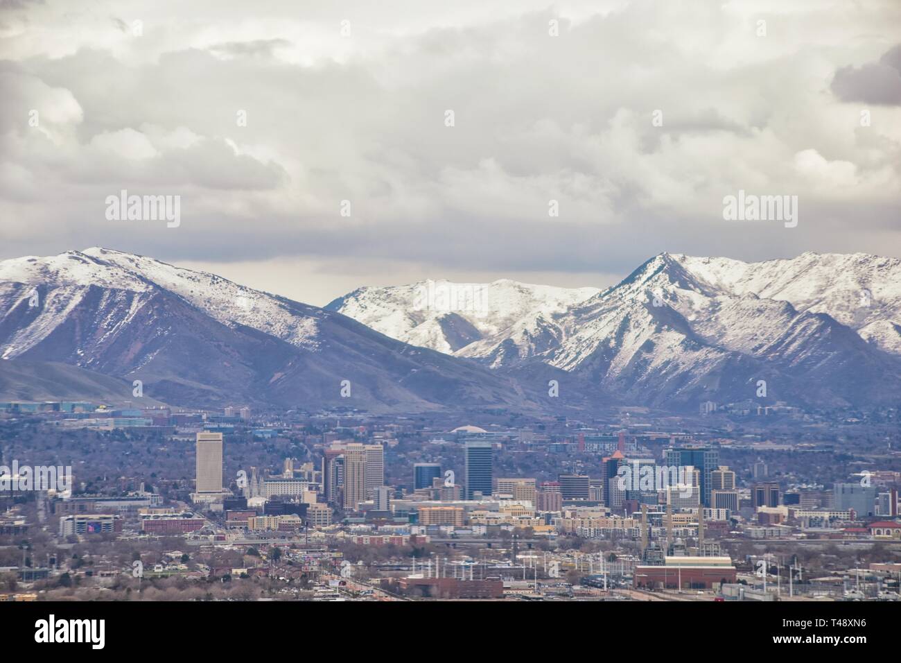 Centro cittadino di Salt Lake City vista panoramica di Wasatch Front Montagne Rocciose da aereo a inizio primavera inverno con fusione della neve e cloudscape. Utah, U Foto Stock