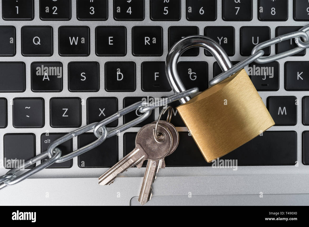 Il lucchetto con catena e le chiavi su un computer portatile tastiera. Cyber security concetto astratto. Foto Stock