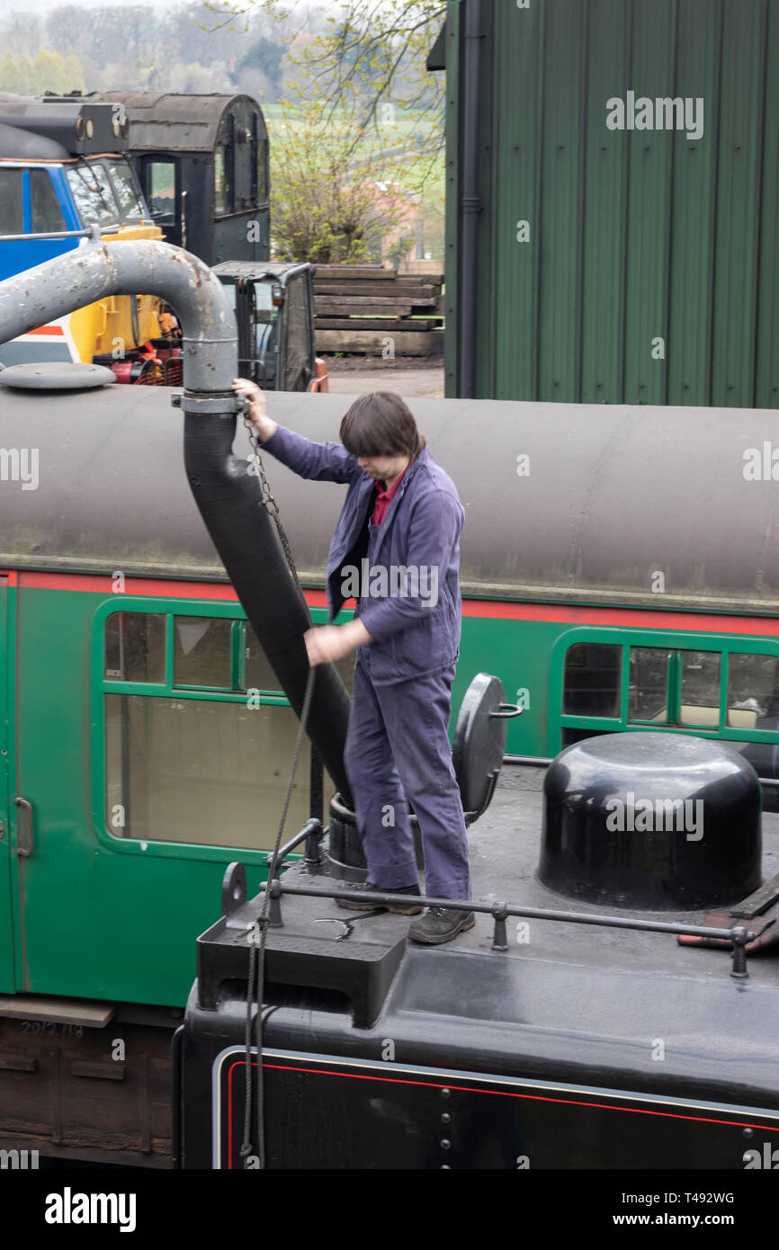 Treno a vapore engineer riempimento di un treno a vapore con acqua Foto Stock
