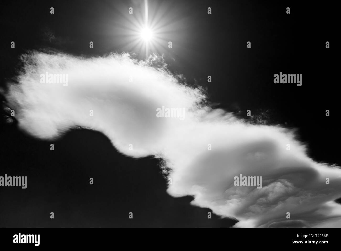 In bianco e nero di sun burst & insolite formazioni cloud contro chiaro cielo blu cobalto; central Colorado, STATI UNITI D'AMERICA Foto Stock
