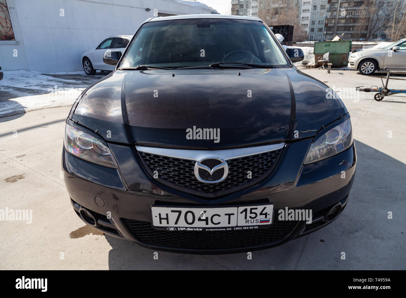 Novosibirsk, Russia - 04.12.2019: Nero Mazda 3 anno 2008 vista frontale con il grigio scuro interno in condizioni eccellenti in uno spazio di parcheggio tra le altre auto Foto Stock