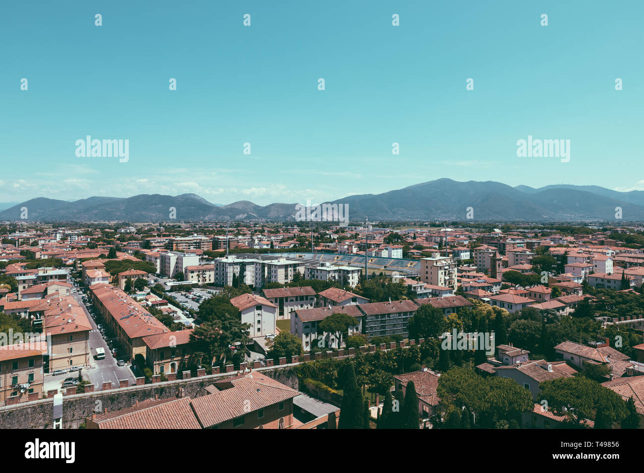 Vista panoramica della città di Pisa con edifici storici e lontane montagne dalla Torre di Pisa. Giorno di estate sole e cielo blu Foto Stock