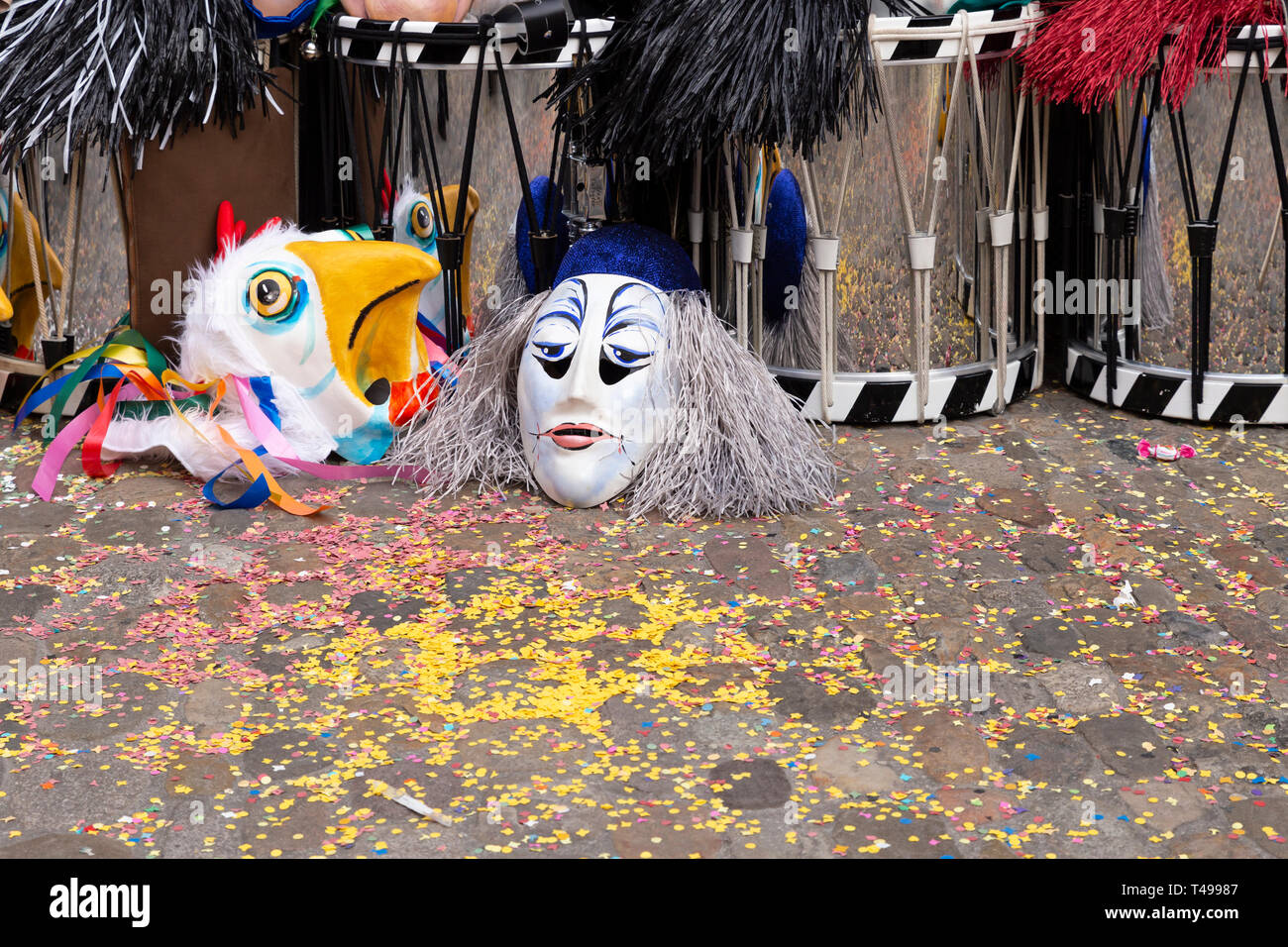 Augustinergasse, Basilea, Svizzera - Marzo 12th, 2019. Maschere di Carnevale e rullanti impilati in un angolo di strada Foto Stock