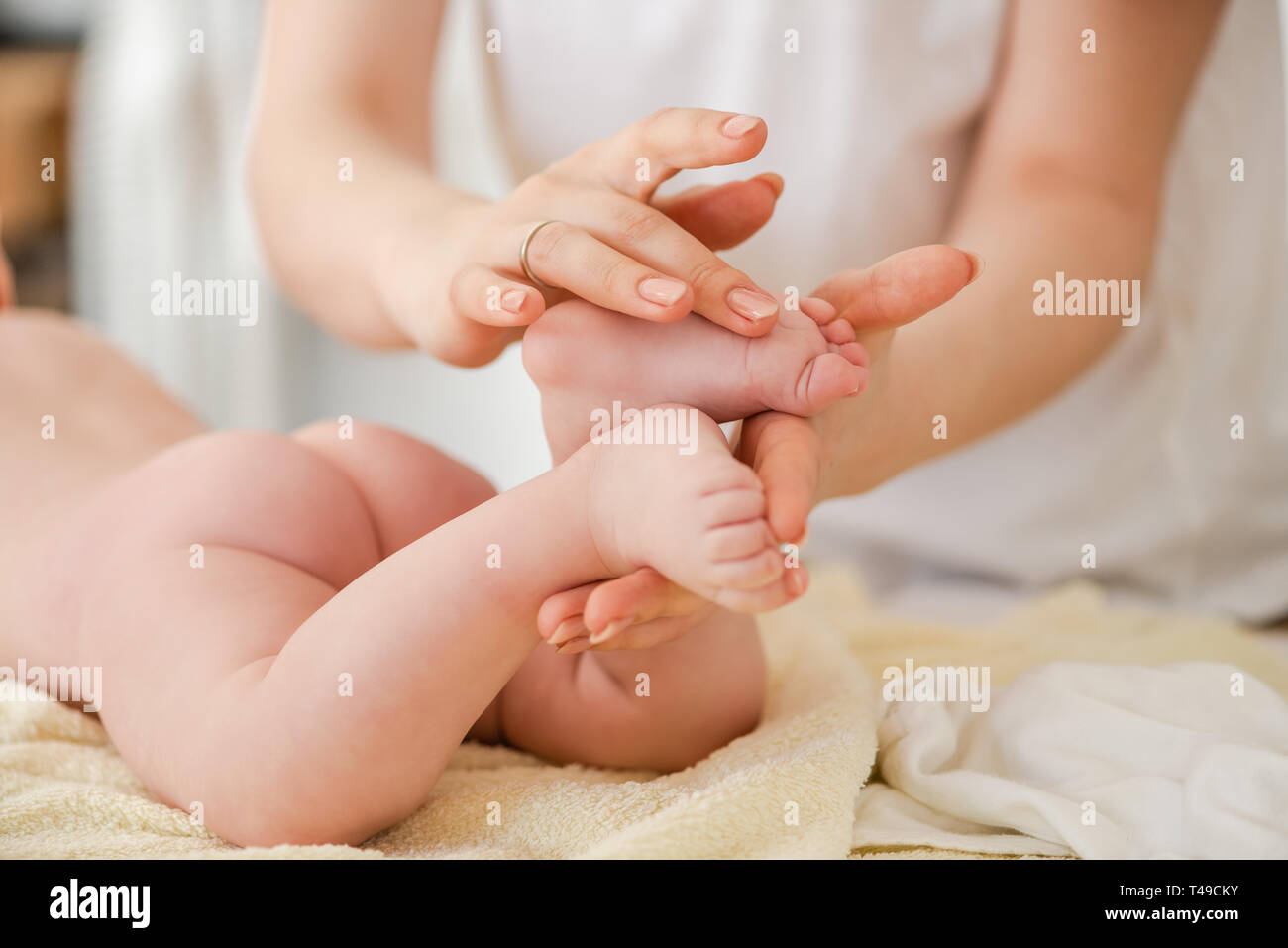 Giovane donna massaggio delicatamente baby dita, close up Foto Stock