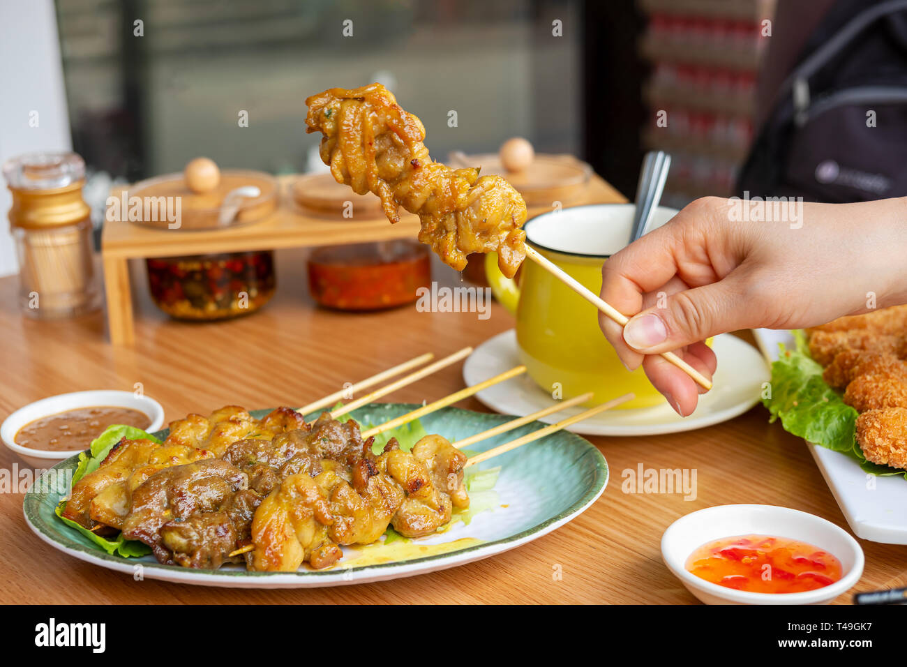Donna mano trattiene un pezzi di saté Foto Stock