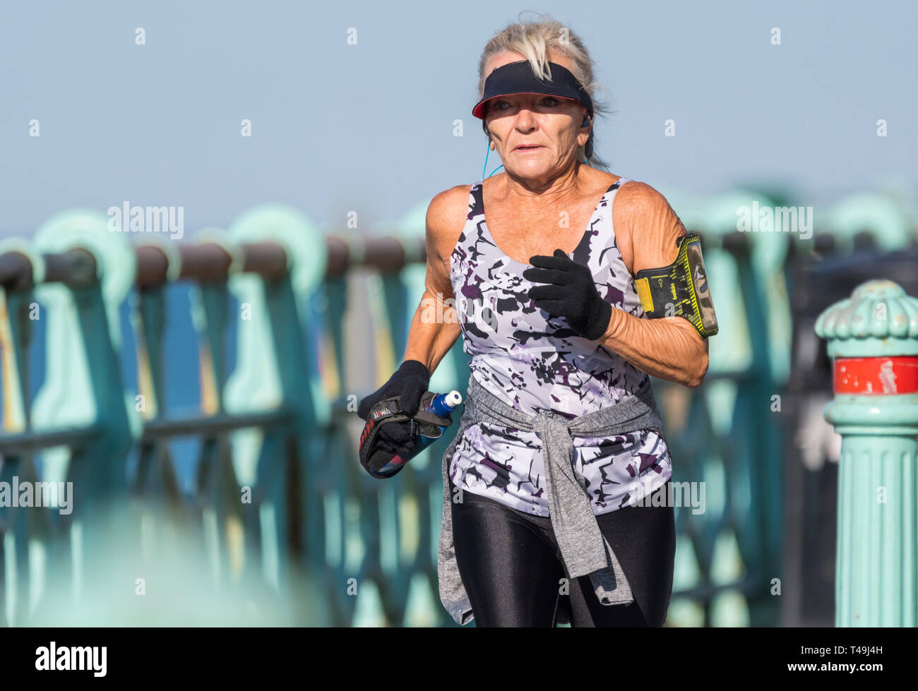 Senior donna jogging su una mattina di primavera in Brighton, East Sussex, Inghilterra, Regno Unito. Signora anziana esercitare e mantenere la misura. Foto Stock