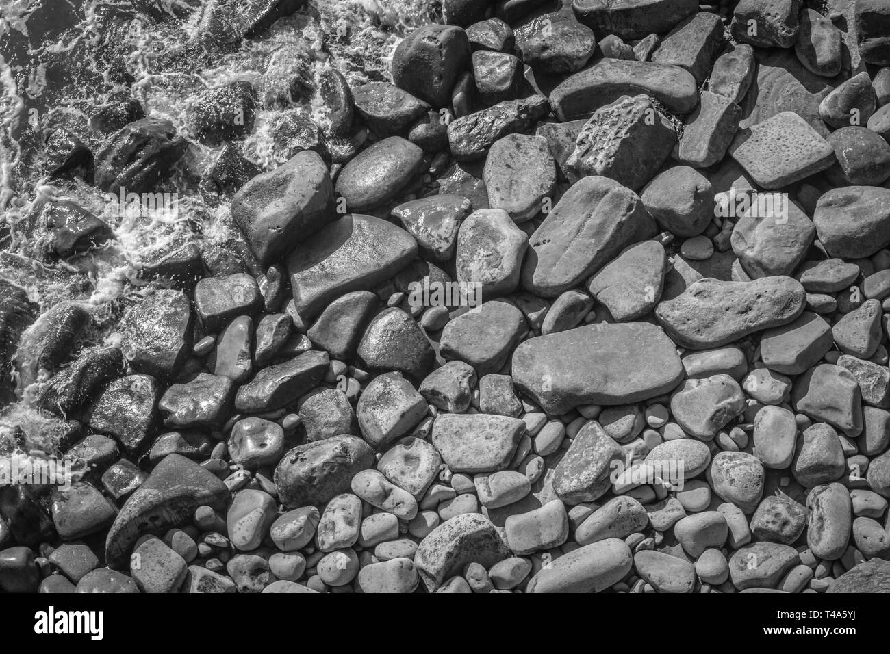 In bianco e nero di rocce nell'oceano sfondo testurizzata Foto Stock