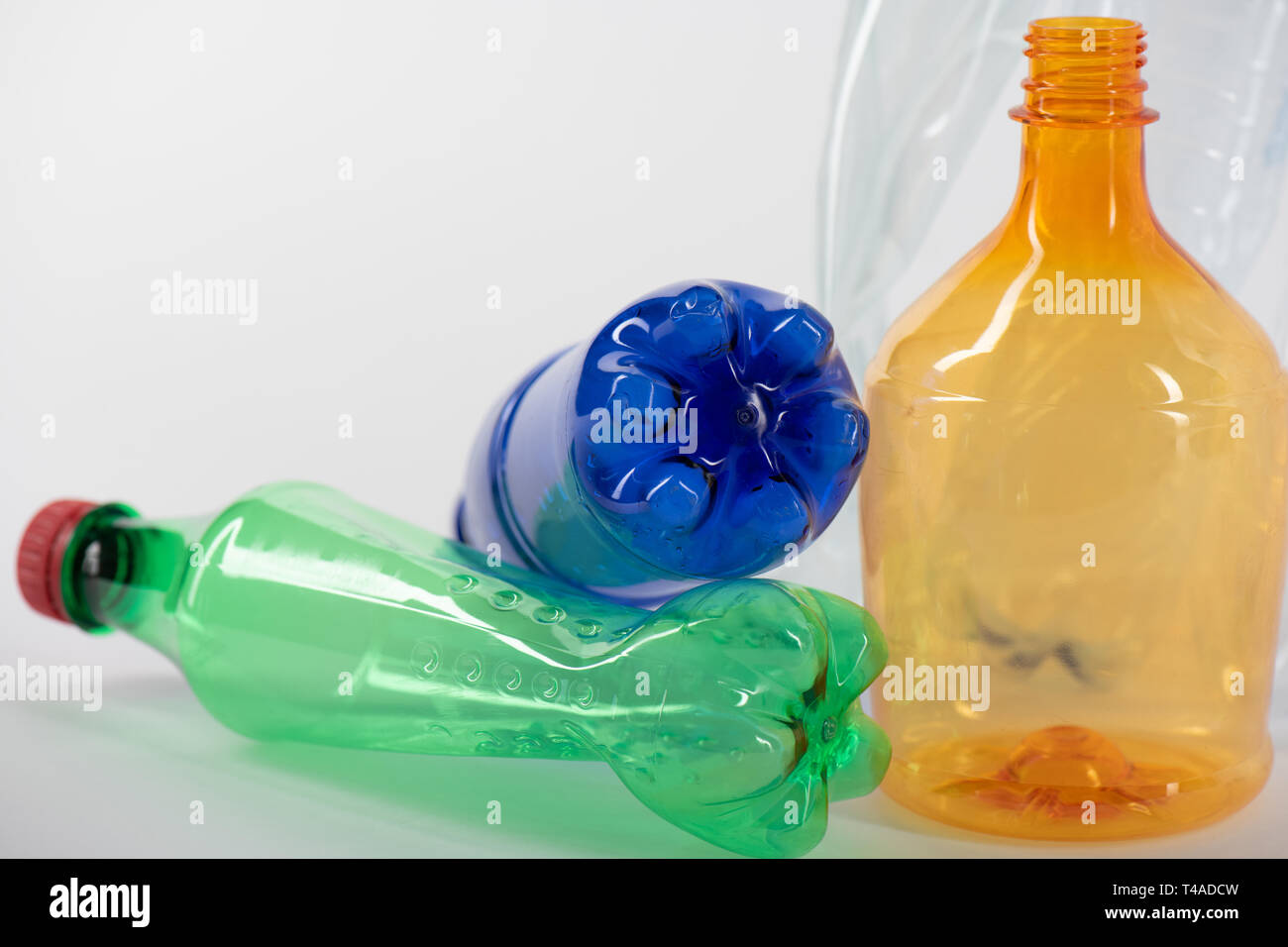 Colorate le bottiglie di plastica posto sulla superficie bianca Foto Stock