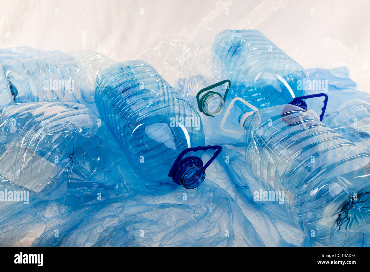 Lo spreco di acqua trasparente bottiglie poste sulla superficie coperta con plastica Foto Stock