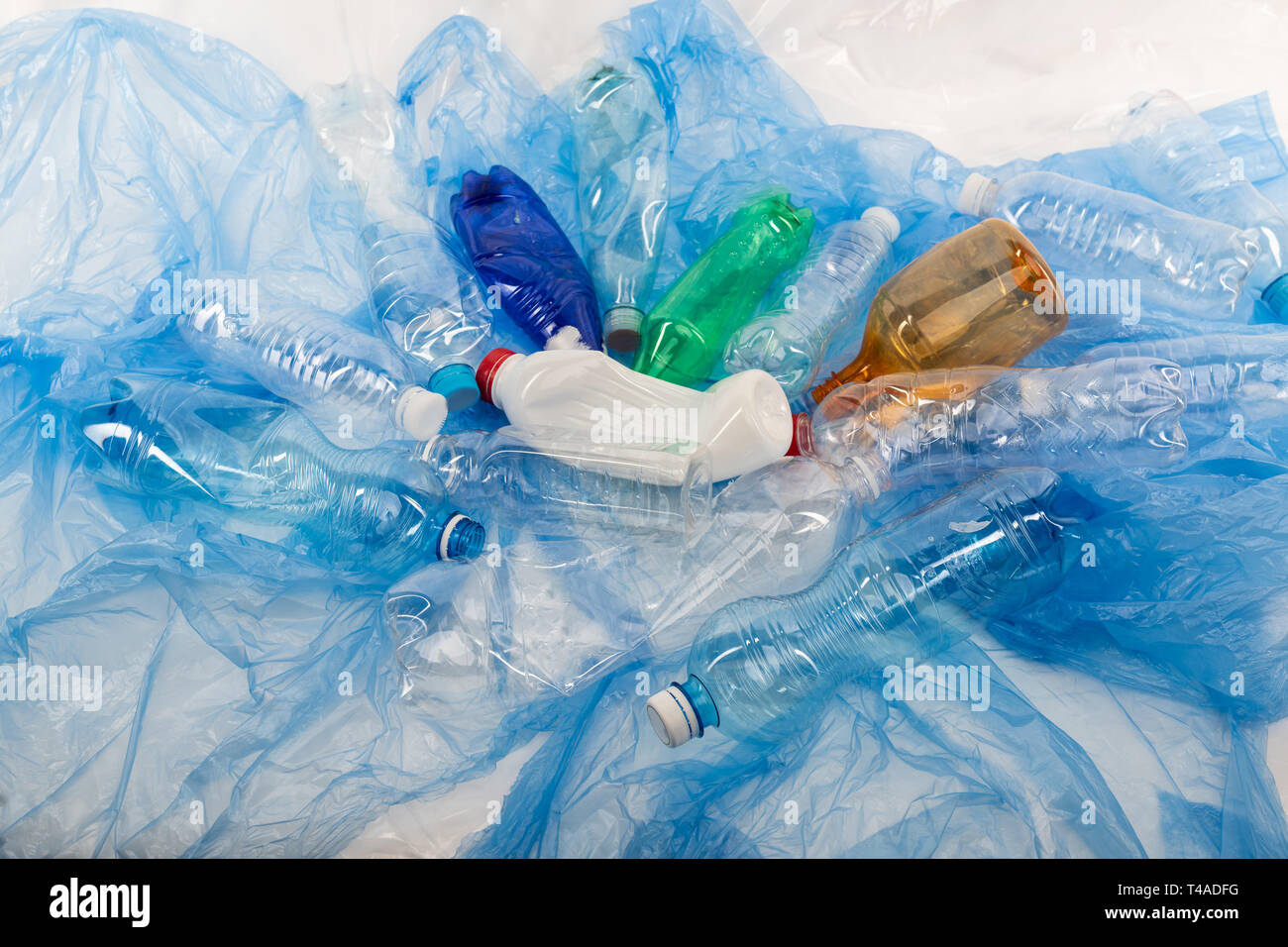 Luminose diverse bottiglie vuote che viene deformato e posto sulla lettiera in plastica Foto Stock