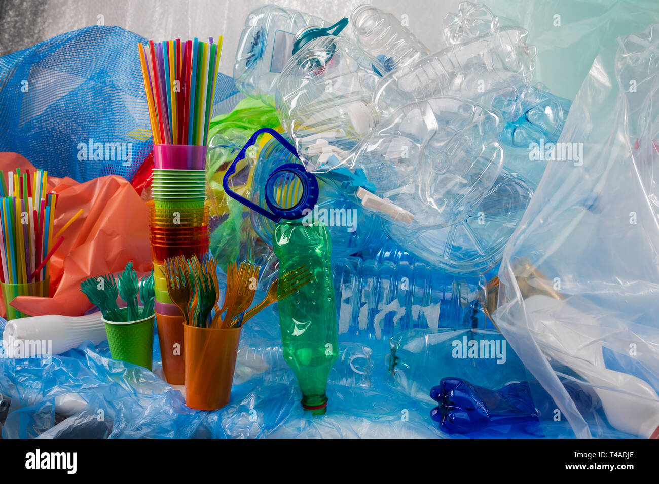 Colorate le forcelle in plastica collocato in una tazza di plastica e in piedi vicino al mucchio di spazzatura Foto Stock