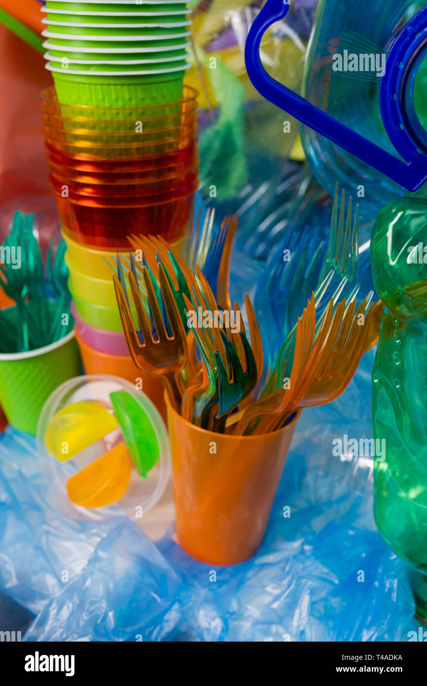 Verde e arancione forcelle monouso in piedi in una tazza di plastica Foto Stock