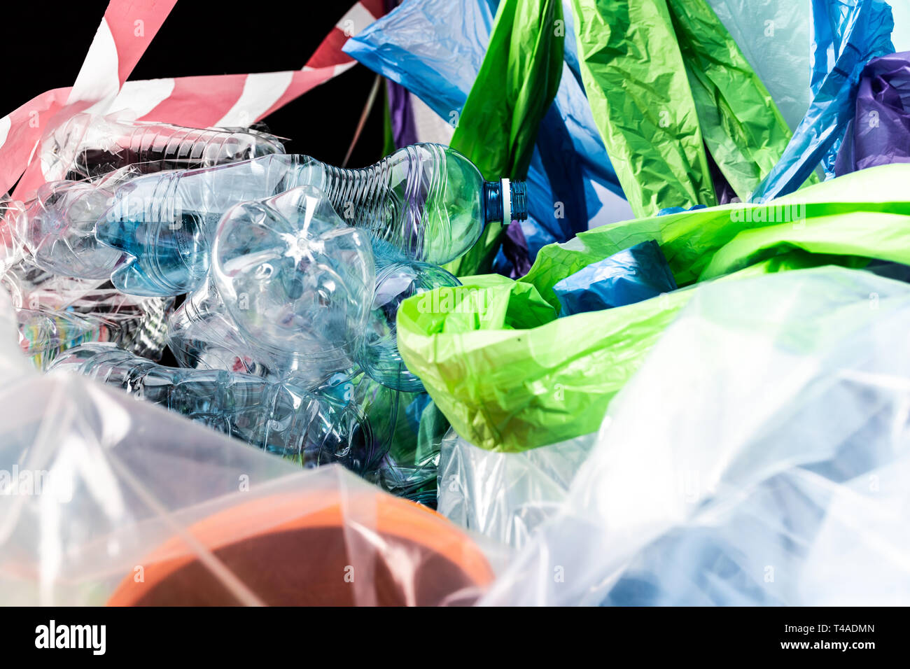Le bottiglie di plastica vuote giacenti con borse e pacchetti Foto Stock