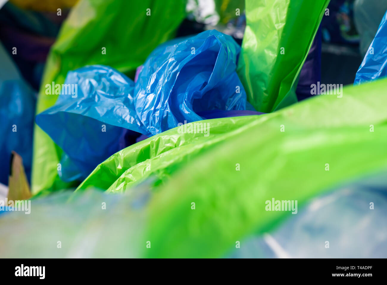 Luminoso avvolge tossici e sacchetti gettati in mucchio di plastica accartocciata Foto Stock