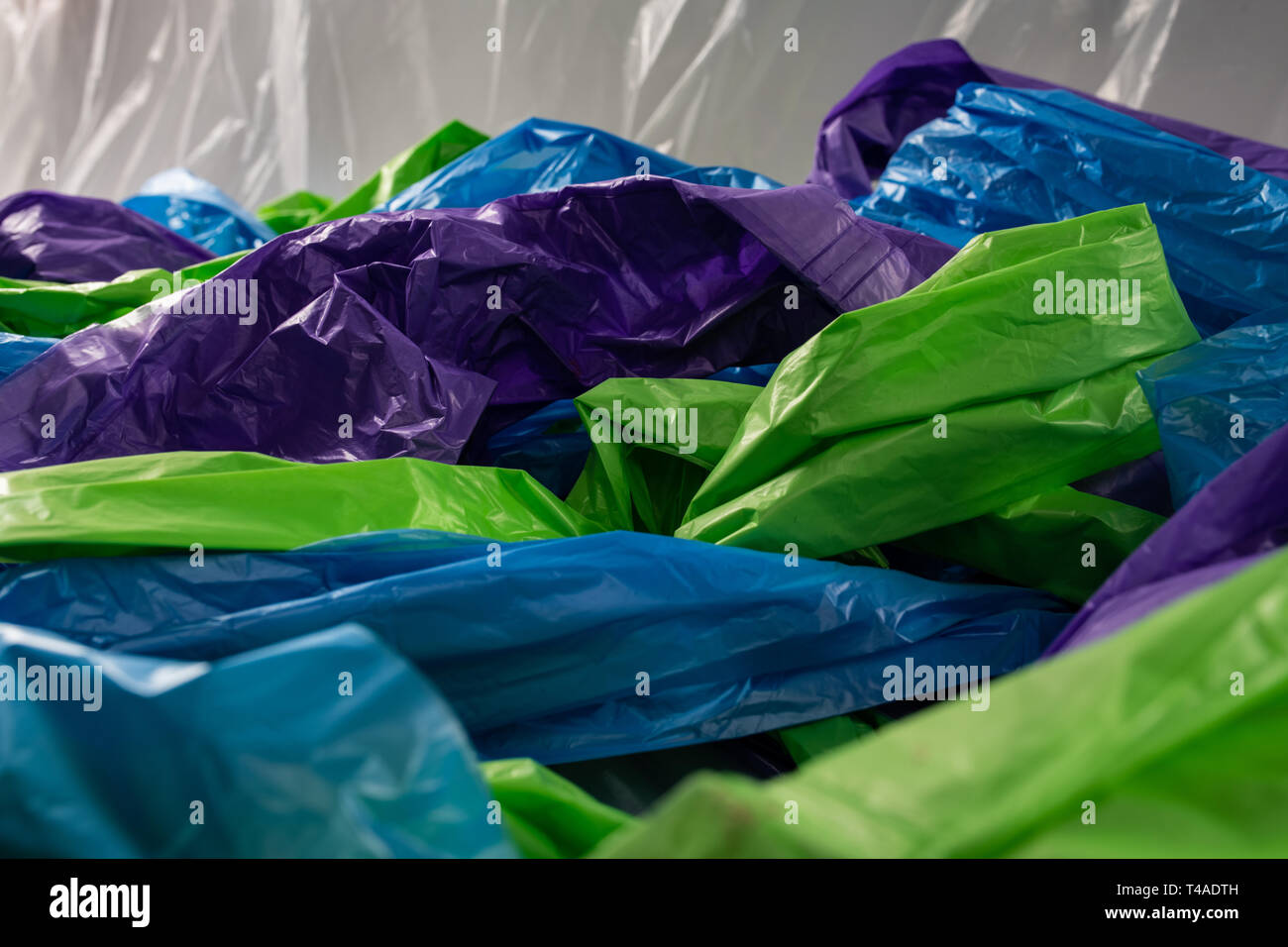 Colorato economici in sacchetti di plastica essendo intrecciate insieme sulla fotocamera Foto Stock