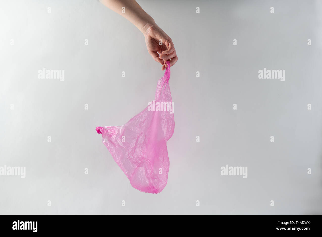Mano azienda viola sacchetto trasparente fatta di economici di plastica sottile Foto Stock