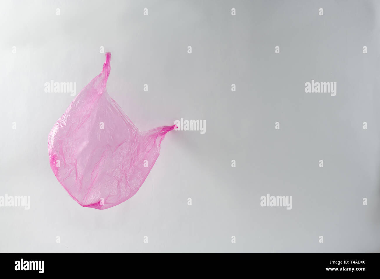 Vuoto accartocciata utilizzato il sacchetto in plastica intorno battenti gettato e dimenticato Foto Stock