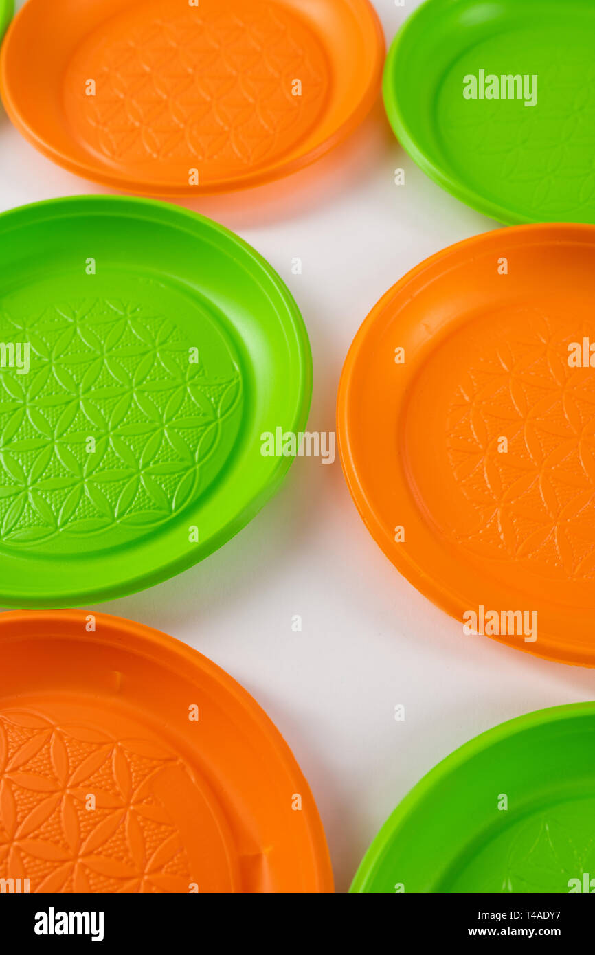 Pericoloso verde e arancione piastre monouso realizzato in plastica dannose Foto Stock