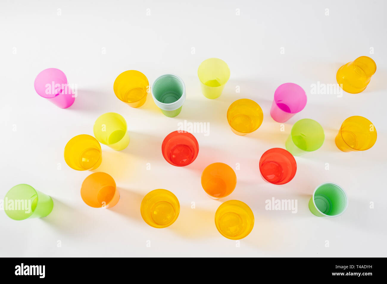 Varie colorate e luminose con bicchieri di plastica in piedi sulla superficie bianca Foto Stock