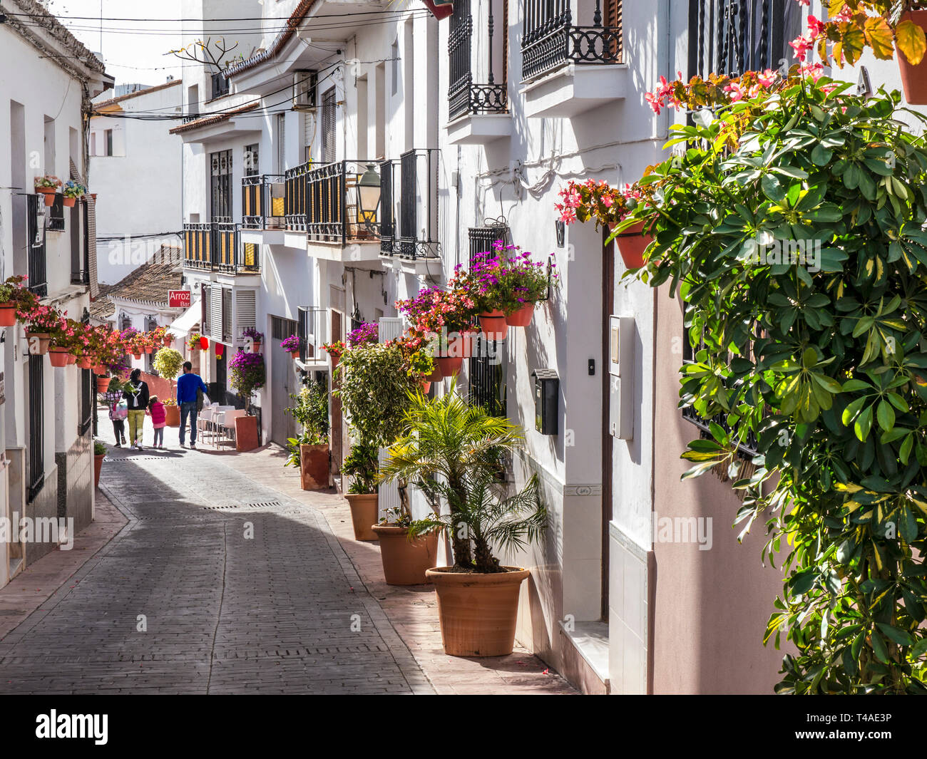 Estepona città vecchia con il bianco lavato edifici tradizionali e vasi di gerani, famiglia esplorando le tranquille strade storiche Estepona, Málaga, Spagna Foto Stock