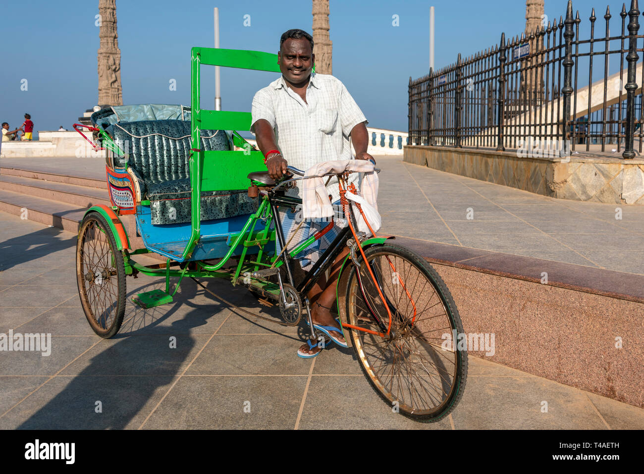 Vista orizzontale di un ciclo rickshaw proprietario e il suo veicolo di Pondicherry, India. Foto Stock
