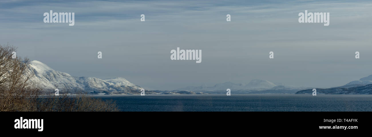 Vista presa dal litorale di Bakkejord, nei pressi di Tromso, Norvegia che mostra la gamma della montagna di distanza. Marzo 2019. Foto Stock