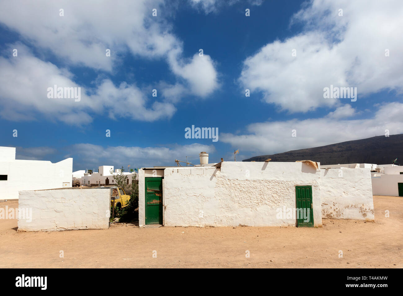 Empty street con sabbia e case bianche e una barca a Caleta de Sebo sull isola La Graciosa di Lanzarote Foto Stock