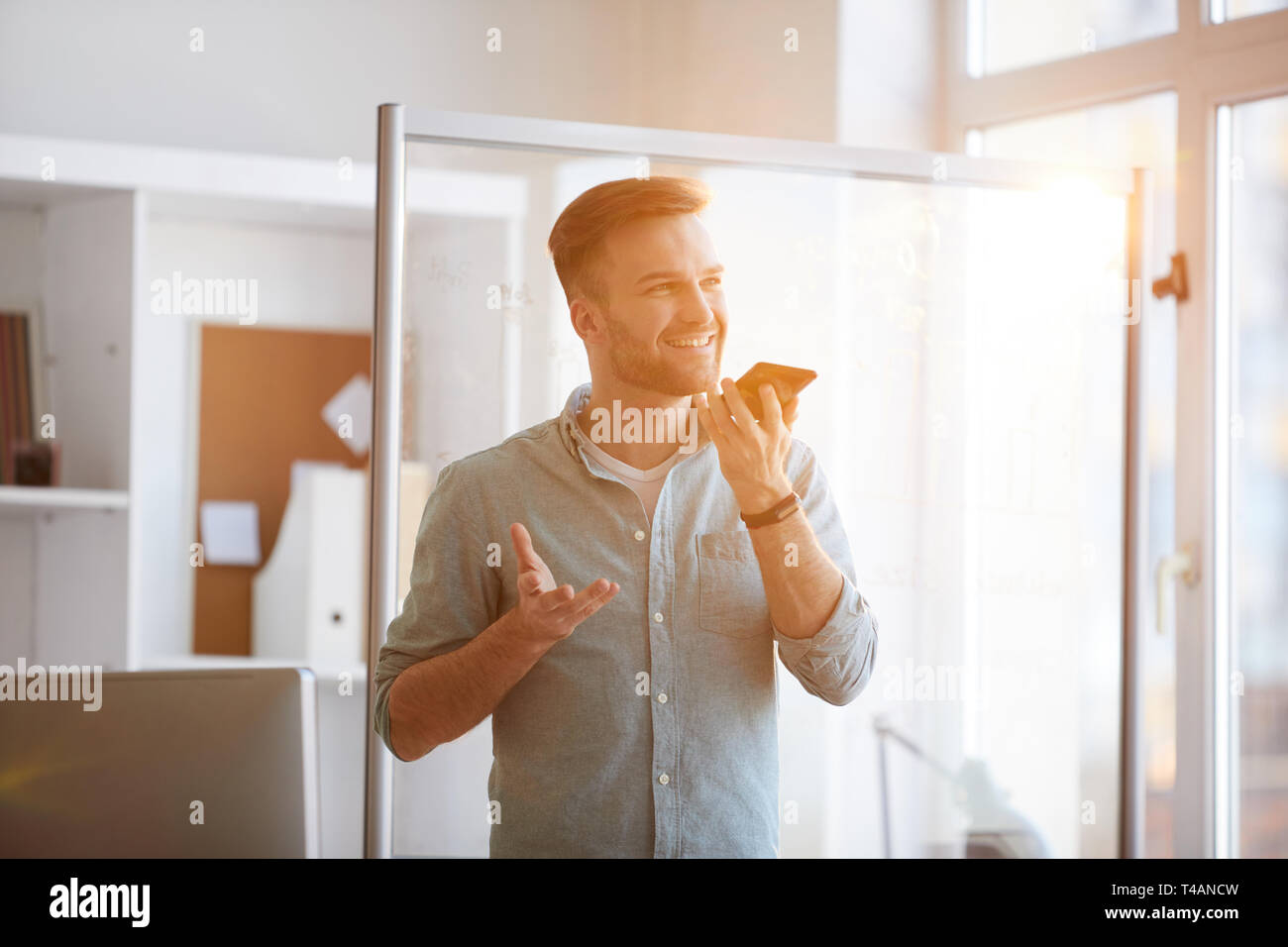 L'uomo contemporaneo usando il telefono alla luce diretta del sole Foto Stock